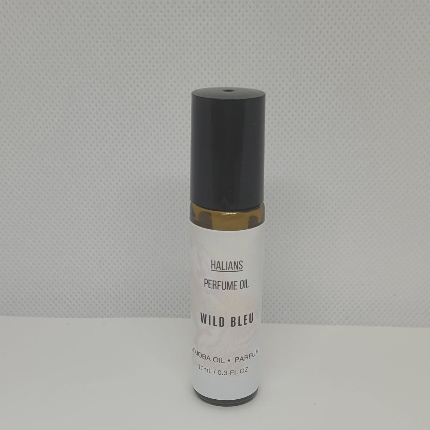 Perfume oil bottle labeled 'Wild Bleu' by HALIANS on a white background